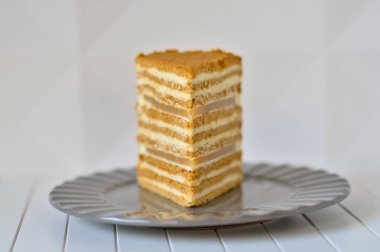 Front view of a Piece of Honey Cake with two layers of pear marmalade staying on a plate