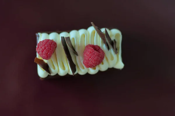 Delicioso Pastel Con Dos Frambuesas Trozos Crujientes Chocolate Encima Mesa —  Fotos de Stock