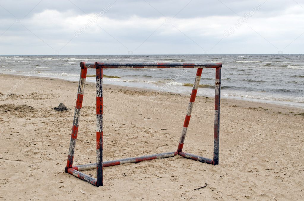 Steel metal football goal gate on sea sand