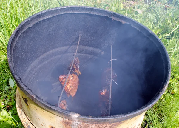 Ecologic fish smoke in smokehouse rusty barrel — Stock Photo, Image