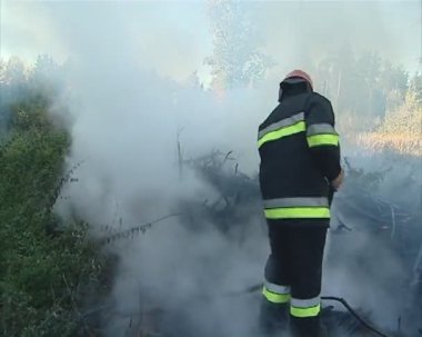 üniformalı itfaiyeci hortumu yangınla mücadele el ile.