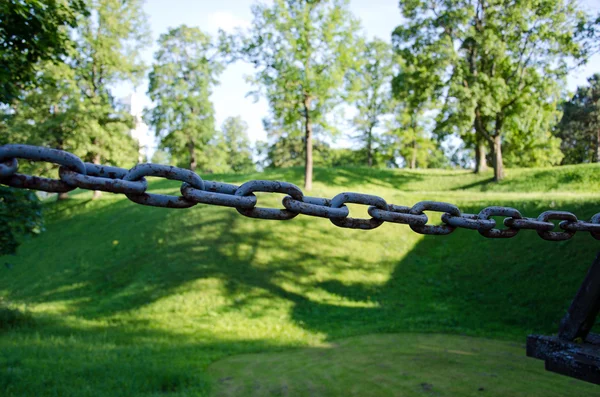 生锈的钢链和模糊的绿色丘陵 — 图库照片