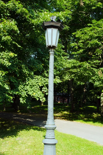 Retro lighting pole lamp in park and linden trees — Stock Photo, Image