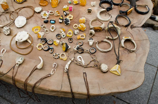Handgjorda smycken ben bärnsten på träbord — Stockfoto