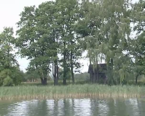 La orilla del lago y el agua ondulada filmada a bordo de un barco a motor . — Vídeos de Stock