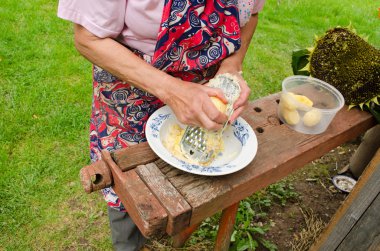 yaşlı kadın el rendeleyin peel patates çelik parçalayıcı