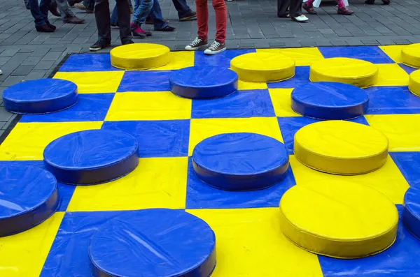 Damas al aire libre juego figuras amarillo azul —  Fotos de Stock
