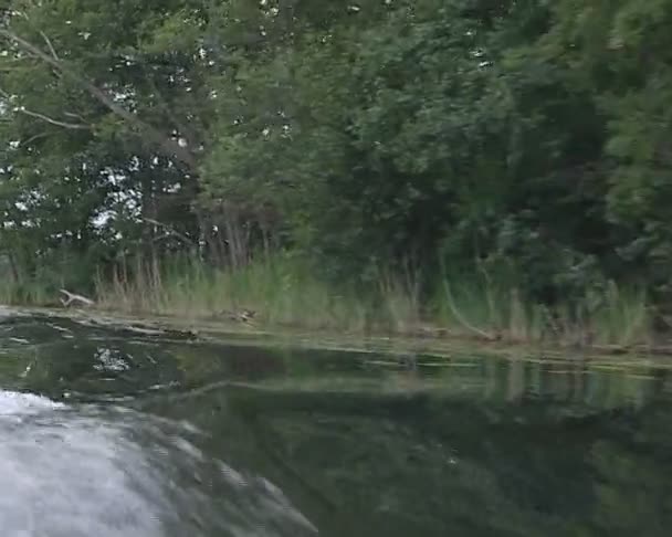 Ondas de água do lago formando a partir de barco a motor flutuante . — Vídeo de Stock