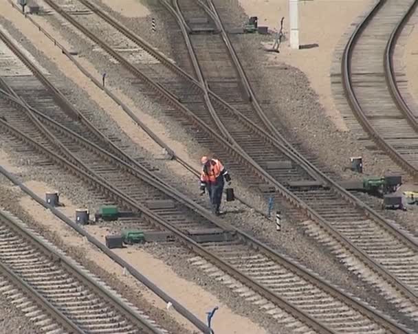 Mannen söker efter järnvägsspåren och en tåg som körs. — Stockvideo