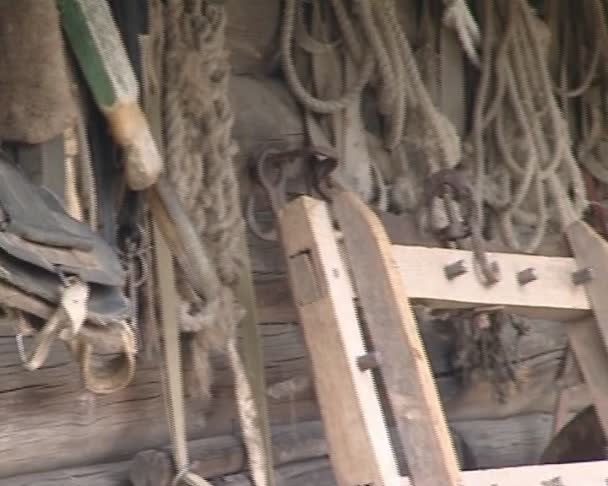 Maison en bois et variété d'outils anciens accrochés au mur .