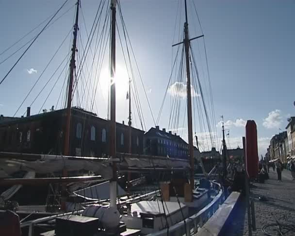 Molo z łodzi w Danii. słońce świeci przez maszt statku. — Wideo stockowe
