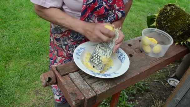 Oude vrouw rasp aardappelen — Stockvideo