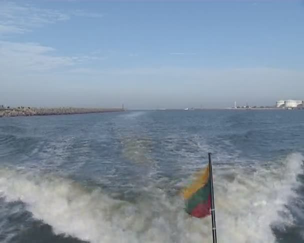 Small lithuanian tricolor flag flying in wind at end of boat. — Stock Video