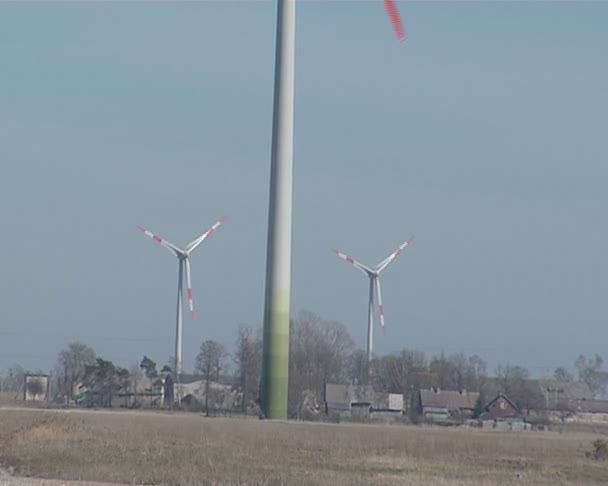 Sombra giratoria del molino de viento en tierra y 4 molinos de viento en distancia . — Vídeo de stock