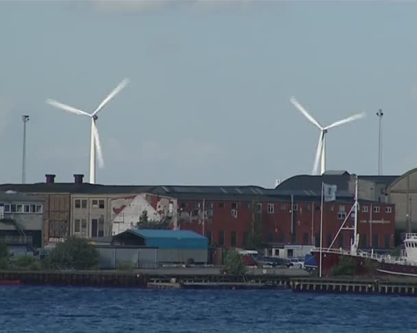 Větrné elektrárny vyrábějící elektřinu u průmyslových staveb. — Stock video