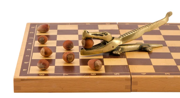 Gold crocodile nut crush tool chess board isolated — Stock Photo, Image
