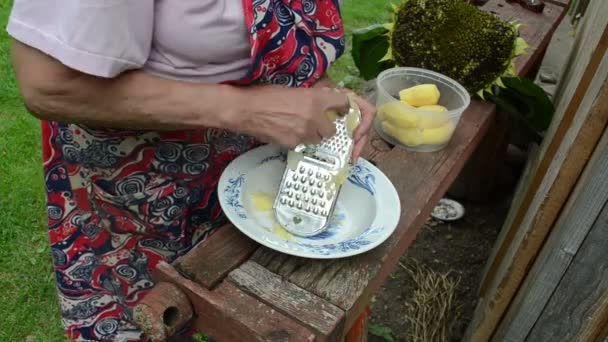 Old woman grater potato — Stock Video