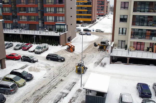 Traktor arbete ren vinter snö lägenhethus parkering — Stockfoto