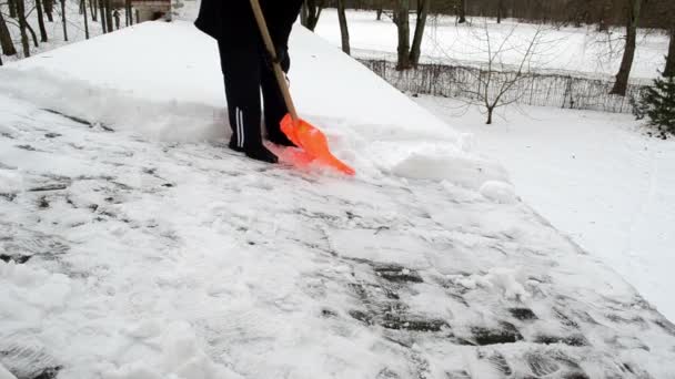 Человек толкает снежную крышу зимой — стоковое видео