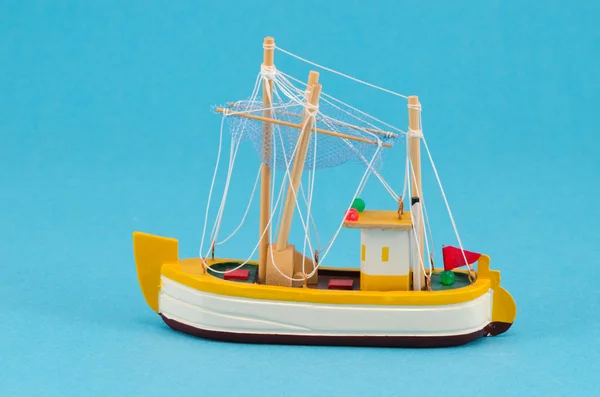 Wooden handmade boat ship model on blue background — Stock Photo, Image