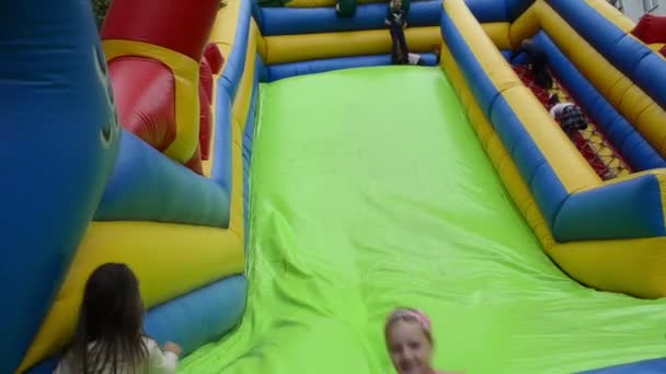 Kinder spielen auf aufblasbarer Blow-up-Spielzeugburg für Kinder auf der Straße — Stockvideo