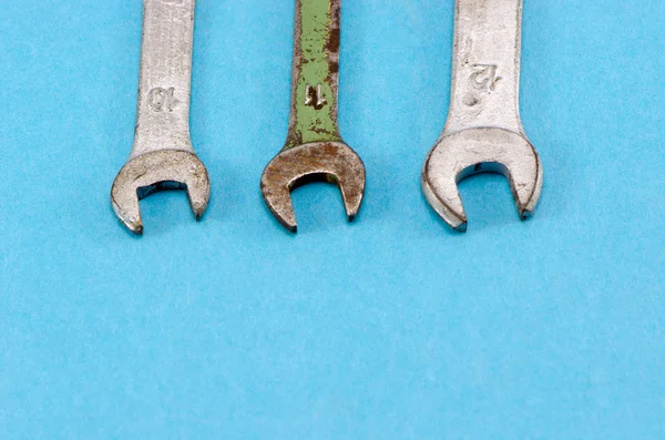 Tres tornillos llaves llaves llaves herramientas fondo azul — Foto de Stock