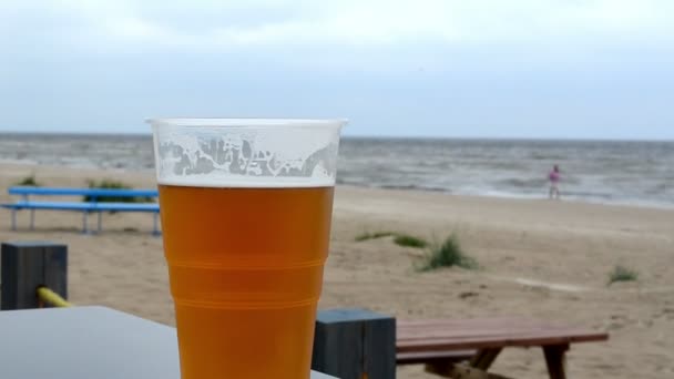 Műanyag pohár sör állvány beach pub tábla háttérben tenger — Stock videók