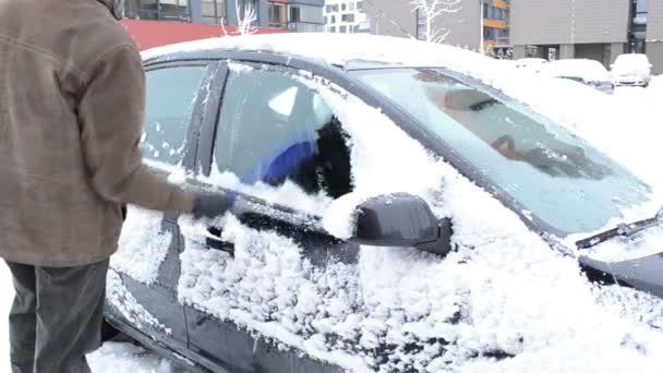 Человек удалить чистые снег автомобиль окно щетка зимняя парковка дом — стоковое видео