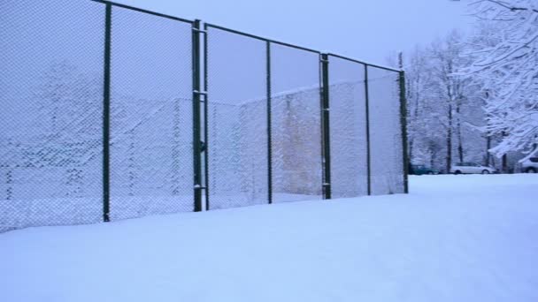 High metal outdoor tennis court fence covered dense snow winter — Stock Video