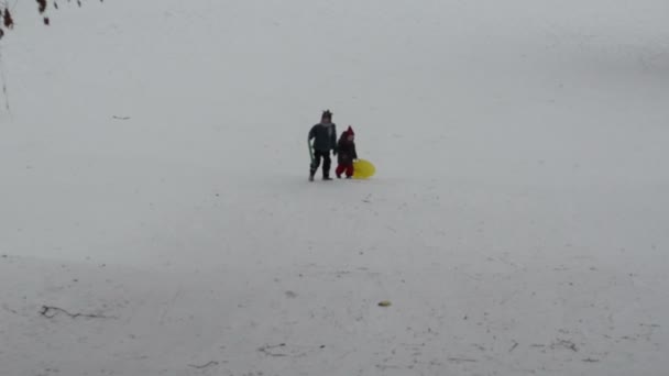 Zus en broer beklimmen berg met sneeuw pads na de landing — Stockvideo