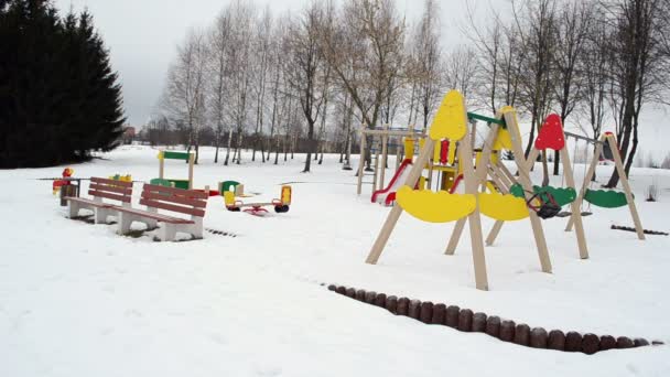 Brinquedos coloridos balançar inverno crianças playground neve — Vídeo de Stock