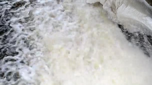 Closeup strong water stream flow spray retro dam ice snow winter — Stock Video