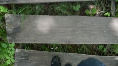 Parktaki eski ahşap merdiven üzerinde ayakkabı ile Man bacaklar tırmanmak