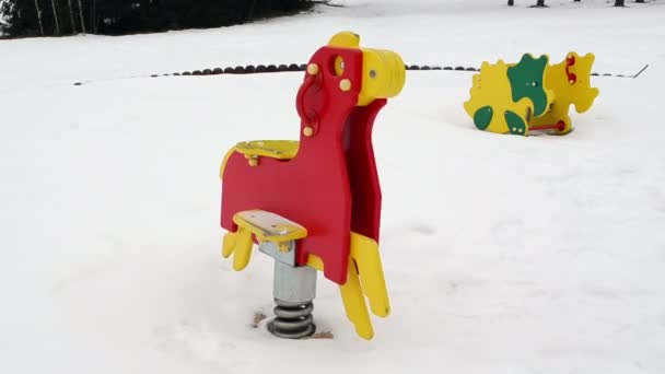 말 모양 다채로운 장난감 이동 배경 겨울 놀이터 눈 — 비디오