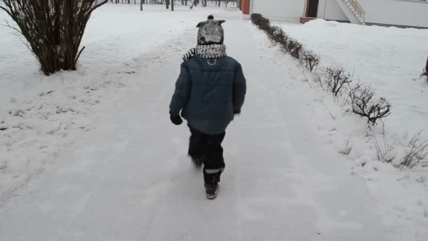 Barn gå till dagis snö väg och lämna deras fotspår — Stockvideo