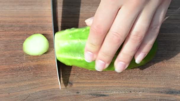 Швидка жінка рука вирізала зелений екологічний огірковий ніж дерев'яна дошка — стокове відео