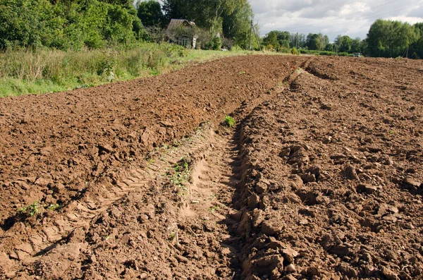 Tractor mark trail soil plow field house farm — Stock Photo, Image