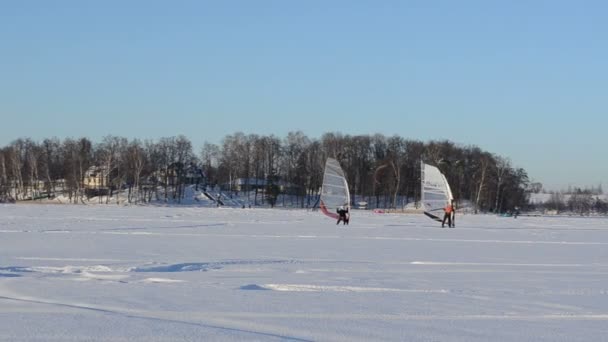 Чоловіки-серфери вітрило замерзле озеро сніг екстремальний спорт — стокове відео