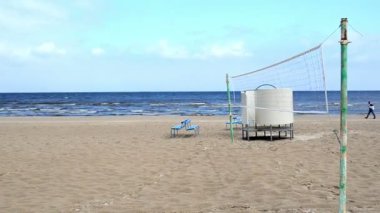 Seaside beach voleybol net mavi banklar ve adam yürümek