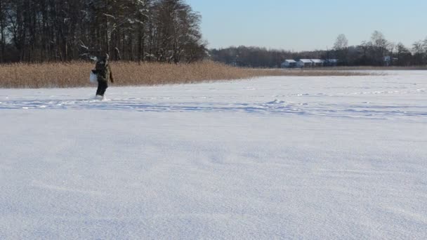 Visser boren vak bevroren meer ijs visserij populaire winter hobby — Stockvideo