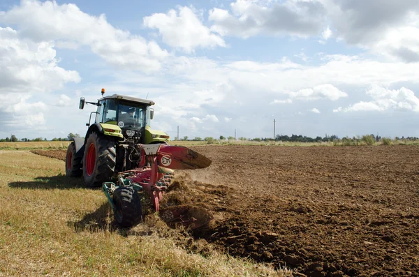 Těžké zemědělské stroje traktor pracuje v oboru — Stock fotografie