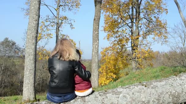 Γυναίκα, μητέρα κάθονται σπασμένα κόρη κορμό δέντρου θαυμάσετε φθινόπωρο δέντρο — Αρχείο Βίντεο