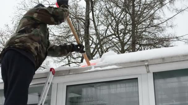 Closeup man camouflage ladder shovel tool clean snow roof winter — Stock Video