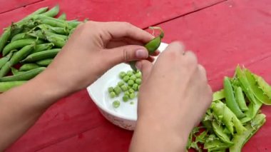 Kadın kadına el pod yeşil bezelye beyaz bulaşık ahşap tablo