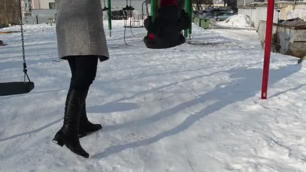 Día de invierno madre con su hija pasar tiempo divertido en el patio de recreo — Vídeo de stock