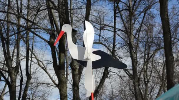 Іграшковий лелека на валу з дерев'яними крилами легко обертається у вітрі — стокове відео
