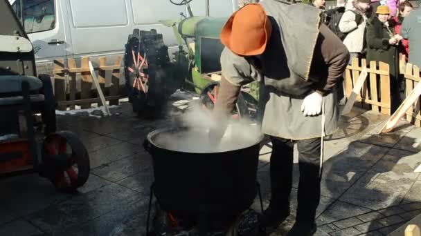 Man jug jar draw hot beer steel pot boil fire spring festival — Stock Video