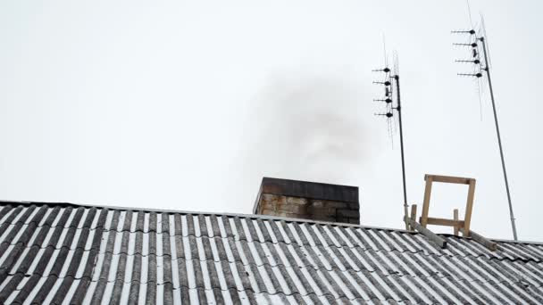 Vecchia casa tetto in ardesia neve scuro fumo salire camino antenna inverno — Video Stock