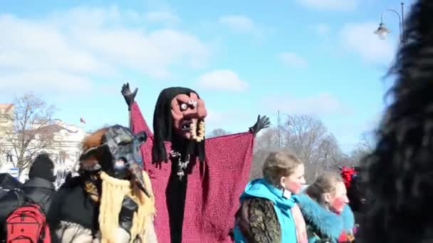 Optocht deelnemers draagt heks masker met een rode mantel — Stockvideo