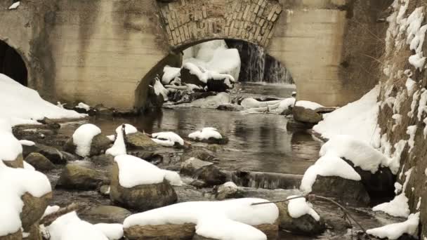 Arroyo flujo de agua correr piedra arquitectura retro arco nieve invierno — Vídeo de stock